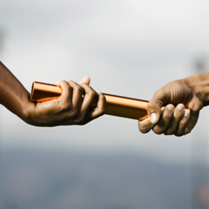 two businessmen passing a baton to each other. 